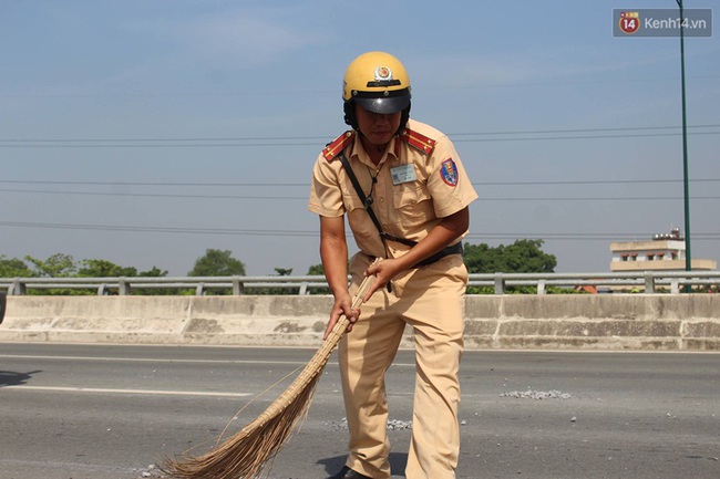 CSGT S&agrave;i G&ograve;n đội nắng qu&eacute;t dọn đ&aacute; rơi tr&ecirc;n đại lộ gi&uacute;p người d&acirc;n - Ảnh 2.