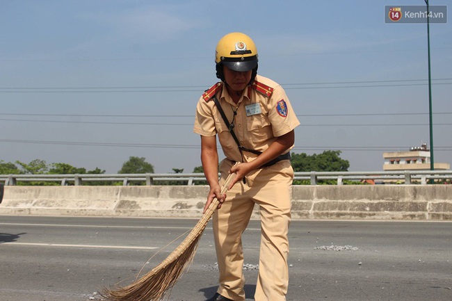 CSGT Sài Gòn đội nắng quét dọn đá rơi trên đại lộ giúp người dân - Ảnh 2.