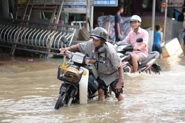 Nắng nóng nhiều ngày ở Sài Gòn, đường phố vẫn ngập lênh láng vì triều cường - Ảnh 2.