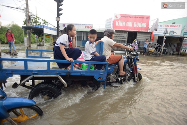 Nắng nóng nhiều ngày ở Sài Gòn, đường phố vẫn ngập lênh láng vì triều cường - Ảnh 6.