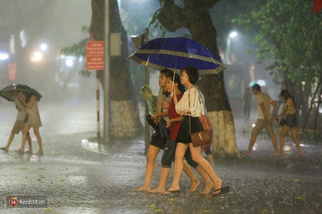 Chùm ảnh: Nhiều người thích thú tắm mưa đến ướt sũng trên phố đi bộ Hà Nội - Ảnh 4.