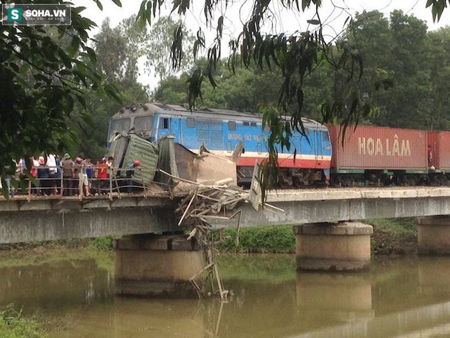 Tai nạn kinh hoàng: Tàu hỏa kéo lê xe tải 50m, giắt vào cầu sắt - Ảnh 1.