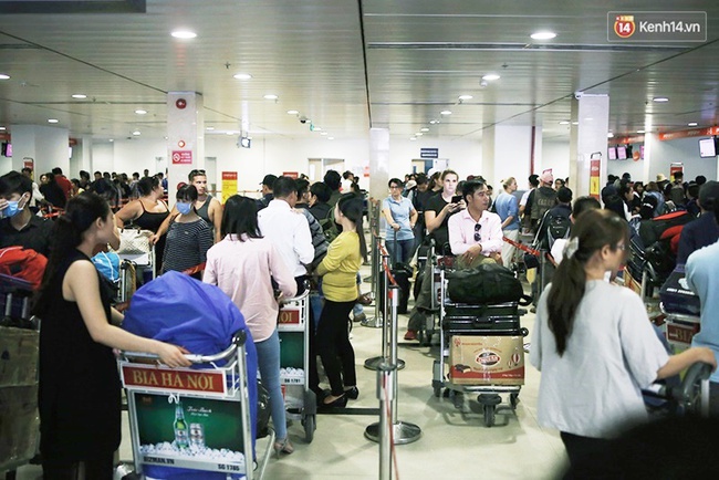 Chùm ảnh: Cận Tết, biển người vật vã hàng tiếng đồng hồ chờ check in ở sân bay Tân Sơn Nhất - Ảnh 2.