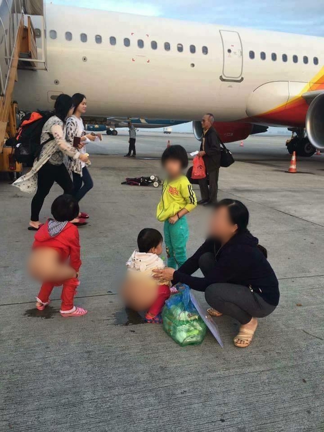 Người mẹ hồn nhiên cho 2 bé gái đi vệ sinh ngay giữa đường băng sân bay - Ảnh 1.