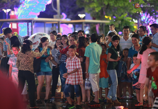 Người lớn, trẻ nhỏ nhảy vào đài phun nước ở đường hoa Nguyễn Huệ để vui đùa đêm Giao Thừa - Ảnh 1.