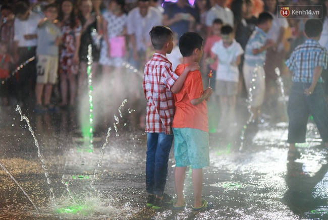 Người lớn, trẻ nhỏ nhảy vào đài phun nước ở đường hoa Nguyễn Huệ để vui đùa đêm Giao Thừa - Ảnh 6.