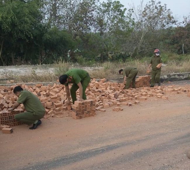 H&igrave;nh ảnh đẹp: Những chiến sĩ c&ocirc;ng an gi&uacute;p người d&acirc;n thu gọn đống gạch đổ từ chiếc xe tải bị lật - Ảnh 3.