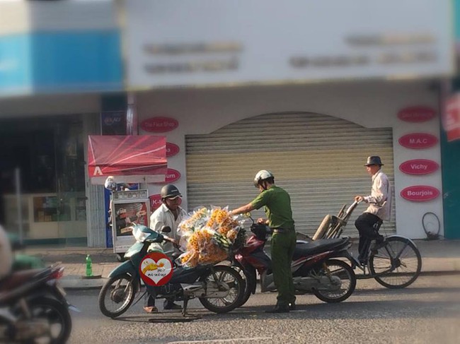 H&igrave;nh ảnh đẹp: C&ocirc;ng an Đ&agrave; Nẵng dừng xe v&agrave; cẩn thận gi&uacute;p b&aacute;c b&aacute;n hoa giữa đường - Ảnh 1.
