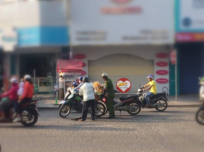 H&igrave;nh ảnh đẹp: C&ocirc;ng an Đ&agrave; Nẵng dừng xe v&agrave; cẩn thận gi&uacute;p b&aacute;c b&aacute;n hoa giữa đường - Ảnh 2.