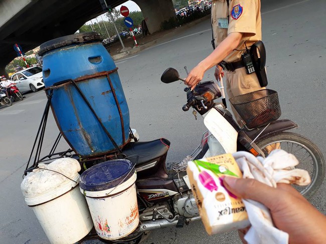 CSGT Hà Nội bê thùng đồ bị đổ giúp người dân giữa giờ tan tầm - Ảnh 2.