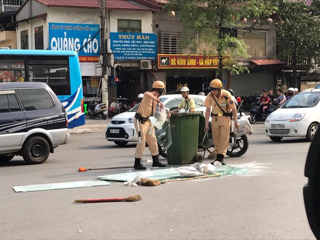 H&agrave;nh động đẹp: CSGT H&agrave; Nội thu gọn những mảnh k&iacute;nh vỡ tr&ecirc;n đường - Ảnh 1.