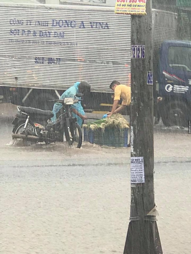 Biên Hòa: Chàng thanh niên phụ giúp người đàn ông bán rau giữa trời mưa to gió lớn - Ảnh 1.