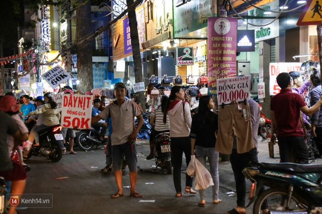 Nhiều nh&acirc;n vi&ecirc;n cửa h&agrave;ng thời trang ở S&agrave;i G&ograve;n cầm bảng gi&aacute; tr&agrave;n ra đường ch&agrave;o mời kh&aacute;ch dịp cận Tết - Ảnh 9.