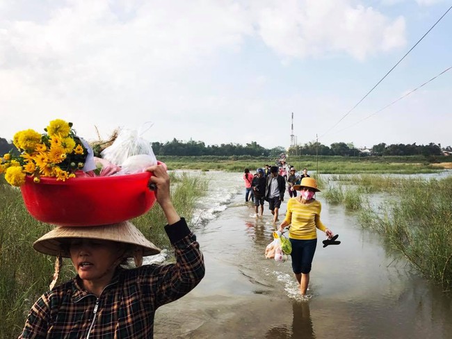 Sáng 30 Tết, mặc mưa lụt cả đoạn đường, bà con Quảng Nam vẫn vui vẻ đi chợ ngày cuối năm - Ảnh 1.