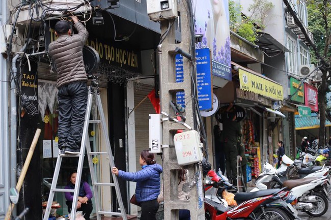 Người dân Hà Nội tự tay tháo dỡ biển quảng cáo, trả lại vỉa hè cho người đi bộ - Ảnh 3.