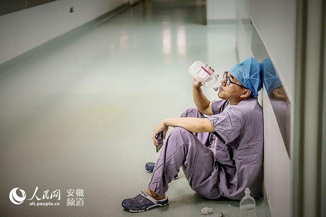 Xúc động trước hình ảnh vị bác sĩ tận tâm ngồi tiếp nước trước cửa phòng phẫu thuật vì kiệt sức - Ảnh 1.