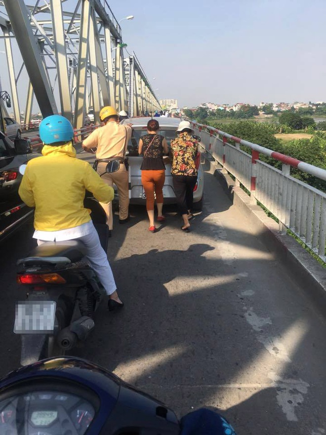 H&agrave;nh động đẹp: CSGT H&agrave; Nội gi&uacute;p hai người phụ nữ đẩy xe &ocirc; t&ocirc; qua cầu Chương Dương - Ảnh 1.