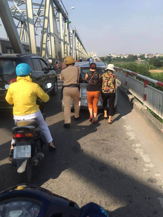 H&agrave;nh động đẹp: CSGT H&agrave; Nội gi&uacute;p hai người phụ nữ đẩy xe &ocirc; t&ocirc; qua cầu Chương Dương - Ảnh 2.