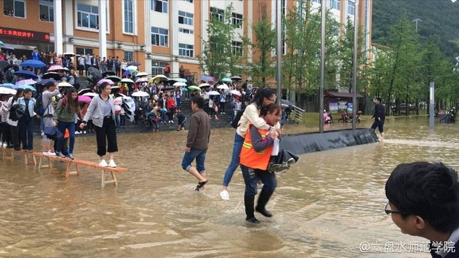 Sinh viên Trung Quốc gây tranh cãi vì để các nữ nhân viên vệ sinh lớn tuổi cõng qua chỗ lội - Ảnh 2.