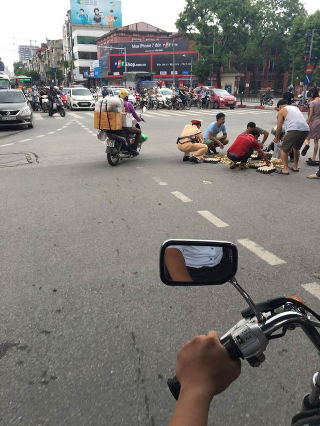 Hành đ&ocirc;̣ng đẹp: CSGT Hà N&ocirc;̣i giúp người d&acirc;n nhặt trứng bị rơi giữa đường - Ảnh 1.