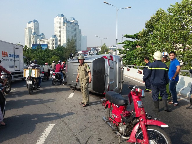 TP.HCM: &Ocirc; t&ocirc; 7 chỗ lật nh&agrave;o tr&ecirc;n đường phố, t&agrave;i xế bung cửa tho&aacute;t th&acirc;n - Ảnh 1.