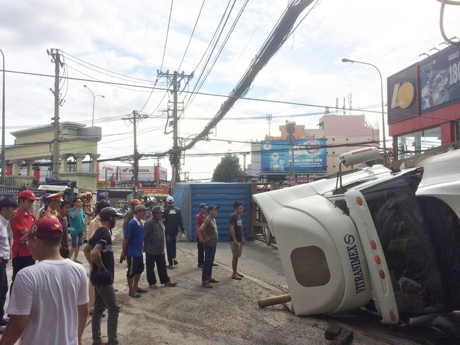 Người đi đường hú vía bỏ chạy vì xe container ôm cua lật ngang giữa phố Sài Gòn - Ảnh 2.