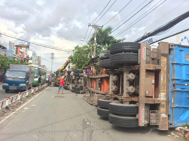 Người đi đường hú vía bỏ chạy vì xe container ôm cua lật ngang giữa phố Sài Gòn - Ảnh 3.