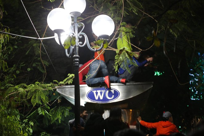 Nhiều thanh niên trèo cây, đứng trên thùng rác, WC... tại phố đi bộ Hà Nội để xem ca nhạc đêm giao thừa - Ảnh 3.