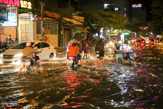 Người Sài Gòn dùng bình gas, thùng bia chắn trước cửa để ngăn nước tràn vào nhà sau cơn mưa lớn - Ảnh 2.