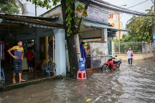 Học sinh ở Sài Gòn bì bõm lội nước sau giờ tan học do mưa lớn kéo dài từ sáng đến trưa - Ảnh 2.