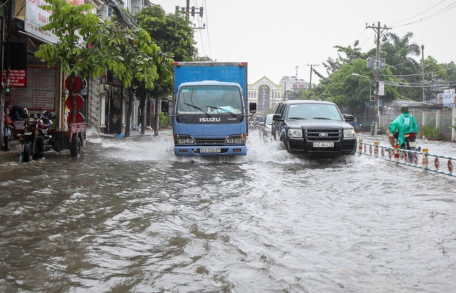 Học sinh ở Sài Gòn bì bõm lội nước sau giờ tan học do mưa lớn kéo dài từ sáng đến trưa - Ảnh 14.