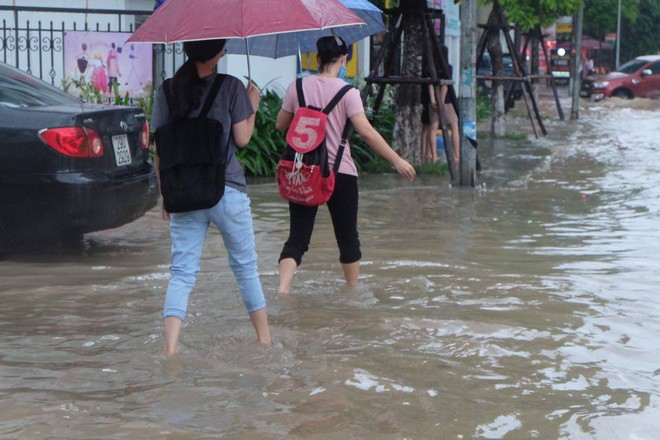 Chùm ảnh: Người Hà Nội mặc áo mưa ăn trưa giữa đường phố ngập lênh láng - Ảnh 6.