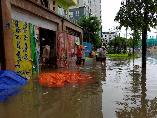 Chùm ảnh: Người Hà Nội mặc áo mưa ăn trưa giữa đường phố ngập lênh láng - Ảnh 9.