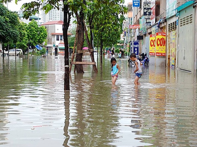 Chùm ảnh: Người Hà Nội mặc áo mưa ăn trưa giữa đường phố ngập lênh láng - Ảnh 11.