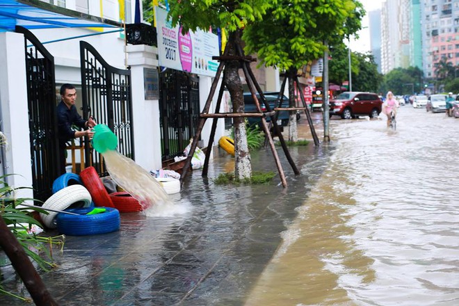 Chùm ảnh: Người Hà Nội mặc áo mưa ăn trưa giữa đường phố ngập lênh láng - Ảnh 12.