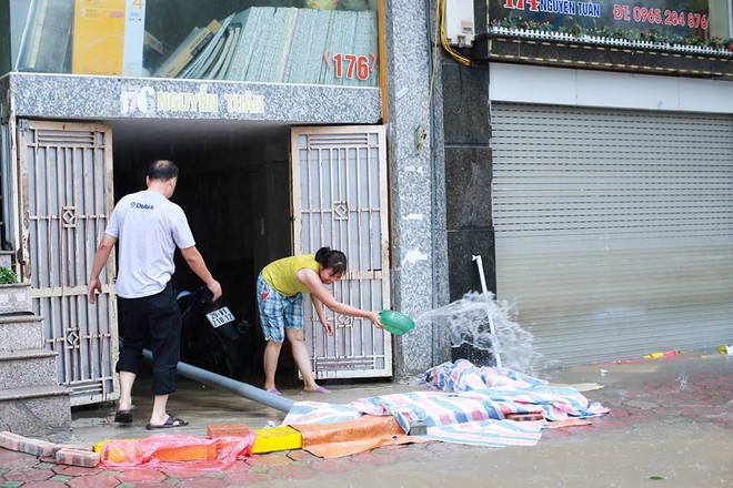 Chùm ảnh: Người Hà Nội mặc áo mưa ăn trưa giữa đường phố ngập lênh láng - Ảnh 13.