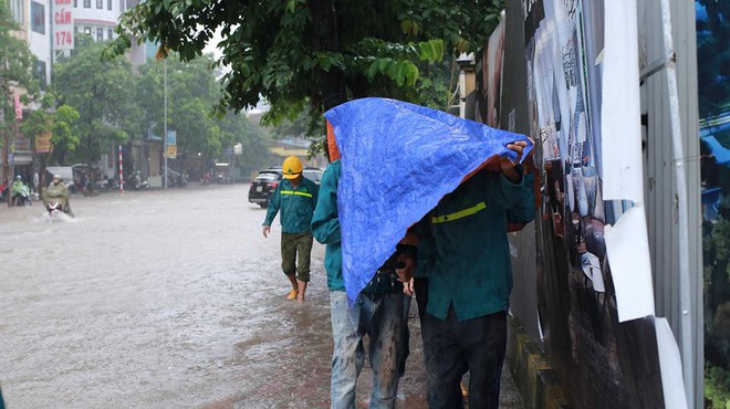 Chùm ảnh: Người Hà Nội mặc áo mưa ăn trưa giữa đường phố ngập lênh láng - Ảnh 5.