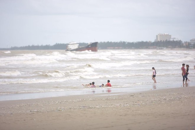 Chùm ảnh: Bất chấp sóng to gió lớn sau bão số 2, nhiều gia đình vẫn đưa trẻ em ra tắm biển Cửa Lò - Ảnh 8.