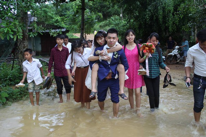 Đám cưới mùa mưa bão: Chú rể hạnh phúc cõng cô dâu qua đoạn đường ngập nước và bùn đất - Ảnh 4.