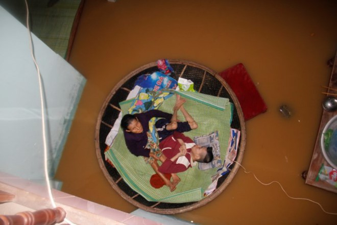 Quặn l&ograve;ng cảnh mẹ 72 tuổi neo th&uacute;ng giữ con chất độc da cam giữa lũ - Ảnh 3.