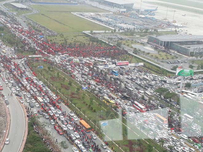 Dù sân bay Nội Bài chật kín, nhiều hành khách vẫn vui vẻ kéo vali đi bộ hơn 1km để vào nhà ga T2 - Ảnh 1.