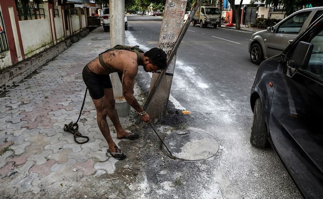 Cận cảnh công việc của các công nhân ngụp lặn trong ống thải ở Ấn Độ - Ảnh 10.