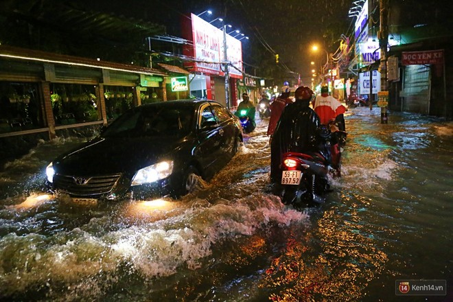 Học sinh, dân công sở khốn khổ vì nước ngập lút bánh xe trong cơn mưa kéo dài đến đêm ở Sài Gòn - Ảnh 9.