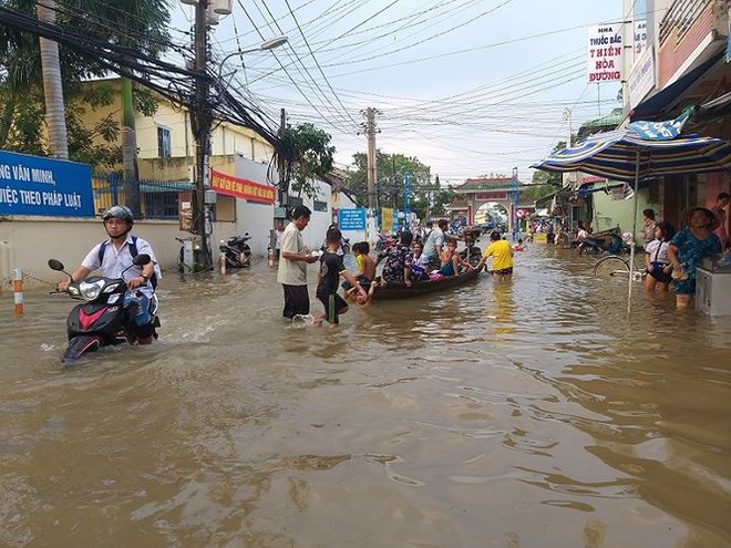 Nước bủa vây, phụ huynh bơi ghe trên phố đón con   - Ảnh 2.