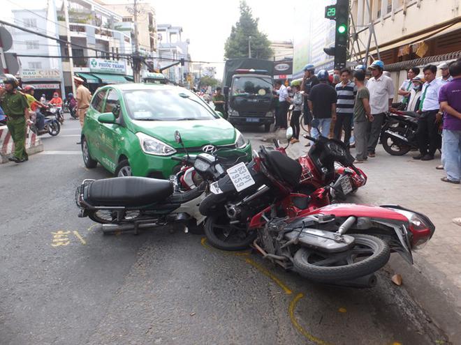 Taxi t&ocirc;ng h&agrave;ng loạt xe m&aacute;y đang dừng chờ đ&egrave;n t&iacute;n hiệu - Ảnh 1.