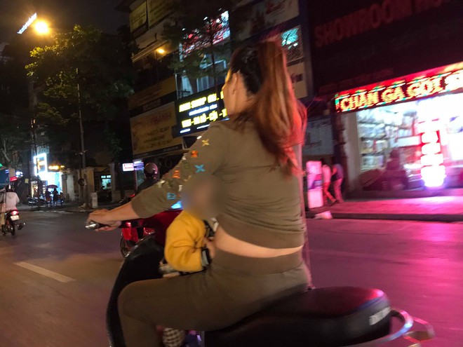 Mẹ một tay cầm l&aacute;i, một tay &ocirc;m con trai đang ti sữa tr&ecirc;n đường g&acirc;y tranh c&atilde;i - Ảnh 1.