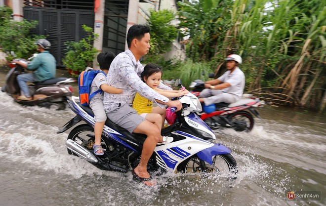 Triều cường dâng cao ở Sài Gòn, cha mẹ khổ sở đẩy xe lội nước đưa con đi học về - Ảnh 8.