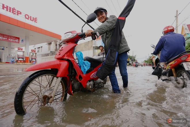 Triều cường dâng cao ở Sài Gòn, cha mẹ khổ sở đẩy xe lội nước đưa con đi học về - Ảnh 13.