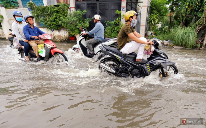 Triều cường dâng cao ở Sài Gòn, cha mẹ khổ sở đẩy xe lội nước đưa con đi học về - Ảnh 9.