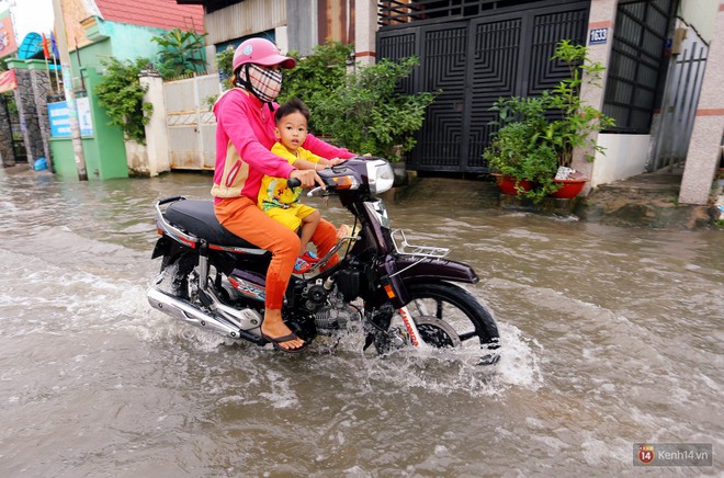Triều cường d&acirc;ng cao ở S&agrave;i G&ograve;n, cha mẹ khổ sở đẩy xe lội nước đưa con đi học về - Ảnh 6.